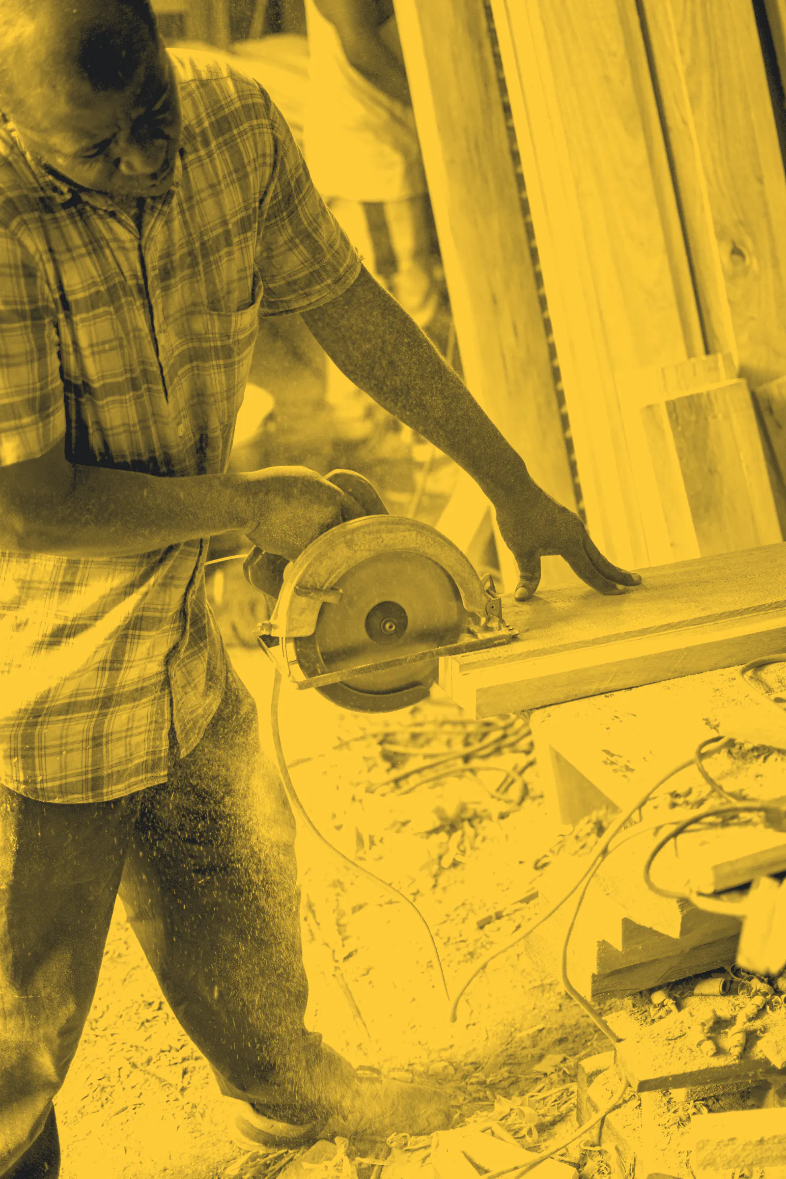 A carpenter cutting timber with a circular saw, sawdust flying