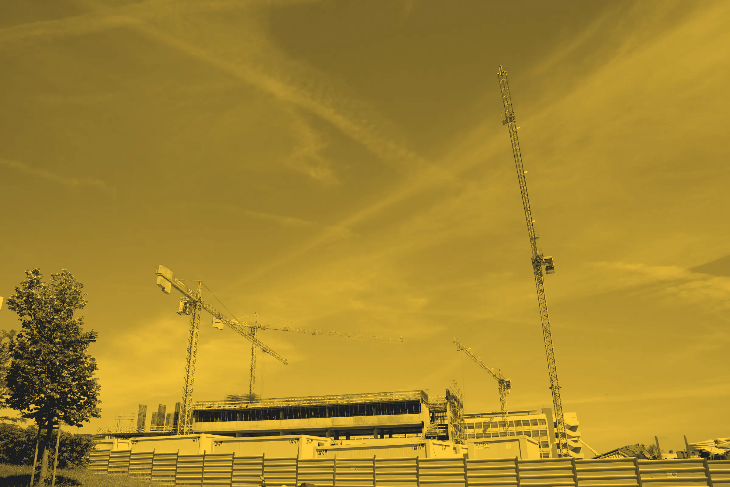 Several tower cranes against an open sky