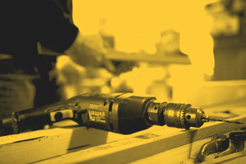 Hands driving a screw with a cordless drill
