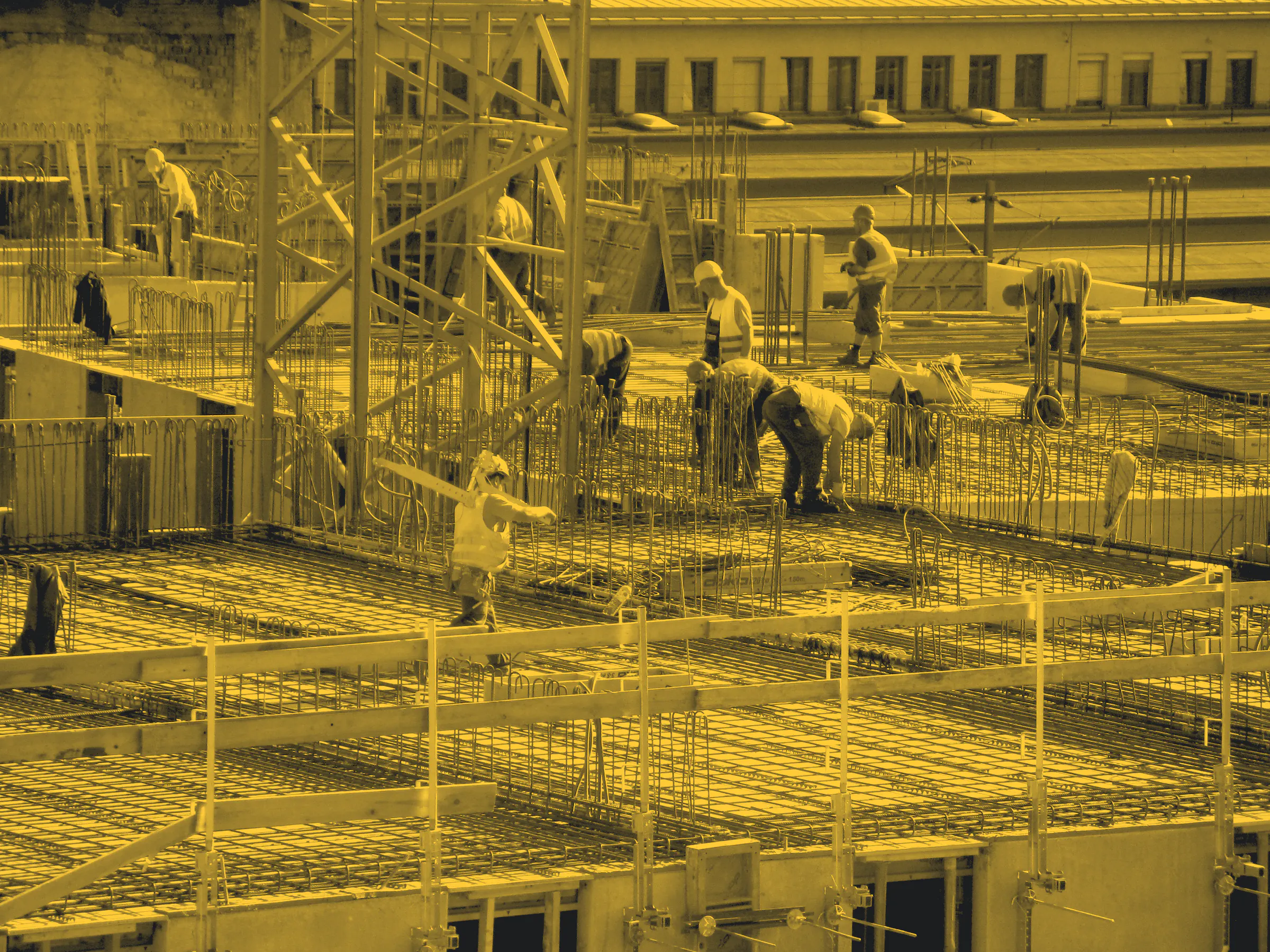 A crew fixing steel reinforcement across a large concrete slab